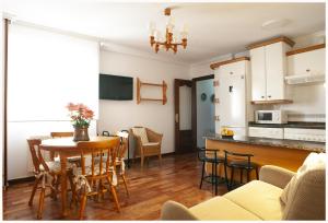 a kitchen and living room with a table and chairs at Llanos Relax VUT 5578 AS in Luanco
