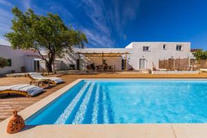 a swimming pool in front of a house at La Quinta da Liberdade - Ferme de charme en Algarve in Pechão