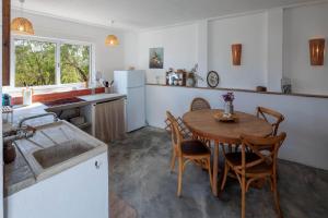 a kitchen with a table and chairs and a sink at La Quinta da Liberdade - Ferme de charme en Algarve in Pechão