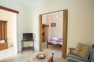 a living room with a couch and a television at GAIA The Cottage House in Nydri +9 photos