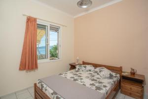 a bedroom with a bed and a window at GAIA The Cottage House in Nydri