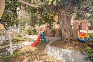 a playground with a tree and a slide at GAIA The Cottage House in Nydri