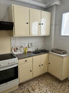 アテネにあるroom pilika4 with shared bath behind the kitchenの白いキャビネットとシンクのあるキッチン
