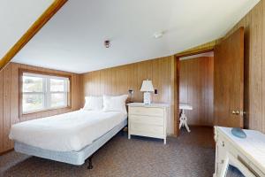 Un dormitorio con una cama y un escritorio y una ventana. en Seaglass Cottage, en York
