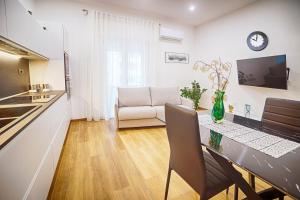 a kitchen and living room with a table and a couch at 5 Minuti dalla Spiaggia - La Casa di Kiki in Oristano