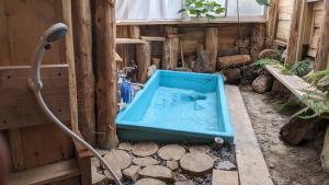 a blue tub filled with water in a room at えころっじKitsuki in Kitsuki