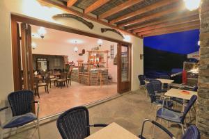 a room with chairs and tables and a dining room at Sifnos Hotel Benaki in Platis Gialos