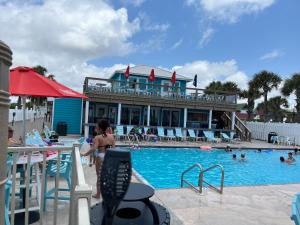 a woman standing in front of a swimming pool at Beach access close to Walmart, Bowling,skating and Game room in Panama City Beach