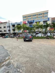 a car parked in a parking lot in front of a building at Penuin Guest House Gaia 09 Batam in Nagoya