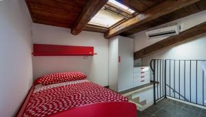 リパトランソーネにあるLa Rocchettaのベッドルーム1室(赤いベッド1台、階段付)