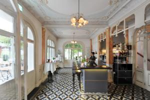 a restaurant with a bar in a room with windows at Jugendstilhotel Paxmontana in Sachseln