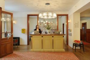 a woman standing at a counter with a laptop at Jugendstilhotel Paxmontana in Sachseln