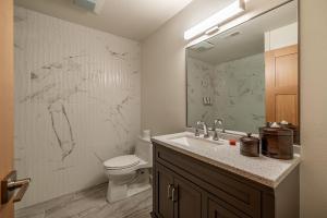 a bathroom with a sink and a toilet and a mirror at Bavarian Lodge Suites in Leavenworth +27 photos