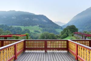 um deque de madeira com vista para as montanhas em Jugendstilhotel Paxmontana em Sachseln
