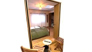 a mirror in a room with a bed and a bedroom at サンルームふじさん in Nebara