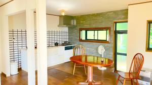 a kitchen with a table and chairs in a room at サンルームふじさん in Nebara