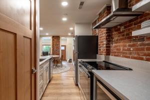 a kitchen with a brick wall and a stove top oven at Bavarian Lodge Suites in Leavenworth