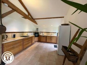 a kitchen with wooden cabinets and a white refrigerator at Grange rénovée avec piscine privative - 4 ch, jardin clos, à 7 km d'Indian Forest - FR-1-426-304 in Le Champ-Saint-Père
