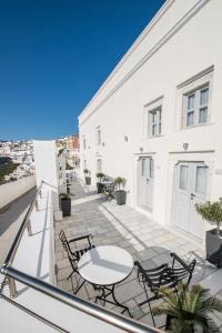 un balcon avec des tables et des chaises sur un immeuble dans l'établissement Archontiko Suites Santorini, à Fira