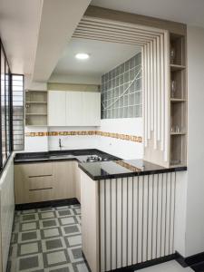 a kitchen with white cabinets and a black counter top at Resort Maldo in Ayacucho