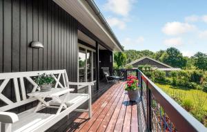 une terrasse en bois avec un banc sur une maison dans l'établissement Holiday Home Træløbervej Tranekær Ii, à Lokkeby