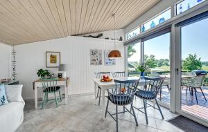 une cuisine et une salle à manger avec une table et des chaises dans l'établissement Holiday Home Træløbervej Tranekær Ii, à Lokkeby