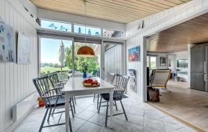 une cuisine et une salle à manger avec une table et des chaises dans l'établissement Holiday Home Træløbervej Tranekær Ii, à Lokkeby