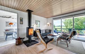un salon avec une cheminée et un canapé dans l'établissement Holiday Home Træløbervej Tranekær Ii, à Lokkeby 10 autres photos