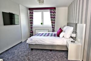 um pequeno quarto com uma cama e uma janela em Apartament Lux em Krościenko