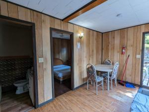 a room with a table and chairs and a bed at Tiny Wood Cottage 07 in Wasaga Beach