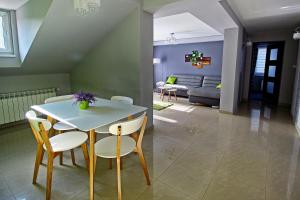 uma sala de estar com uma mesa e cadeiras e um sofá em Apartament Lux em Krościenko