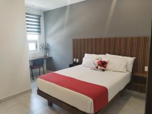 a bedroom with a large bed with a red and white blanket at Hotel Cermar Plaza in La Barca