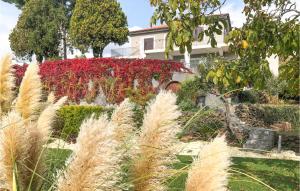 a garden in front of a house with red flowers at Nice Home In Viagrande With Wifi in Viagrande