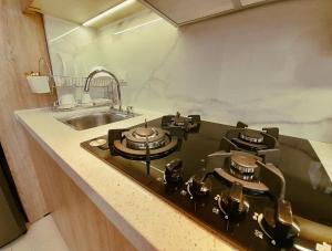 クエンカにあるElegante Suite Privada en Cuenca - Parqueo Incluidoのコンロとシンクのあるキッチン