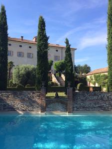 een huis met een zwembad voor een gebouw bij Castello di Coazzolo in Neive