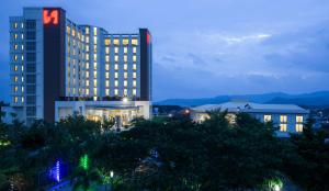 a tall building with lights on in a city at night at Swiss-Belhotel Lampung in Bandar Lampung