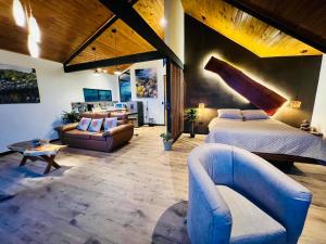 a large bedroom with a bed and a couch at Cabañas de Montaña Magia del Poás in Poás