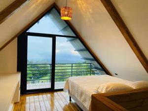 a bed in a room with a large window at Cabañas de Montaña Magia del Poás in Poás +33 photos