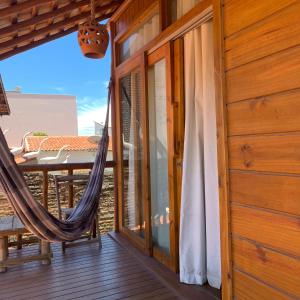 a hammock on the balcony of a house at Chalé do beco,flecheiras in Trairi
