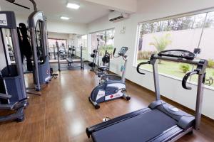 a gym with several treadmills and elliptical machines at 50+ Hotel Flat in Sao Jose do Rio Preto