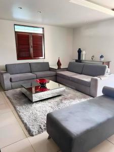 マセイオにあるCasa em Maceió 15min da Praia!のソファとテーブルのあるリビングルーム