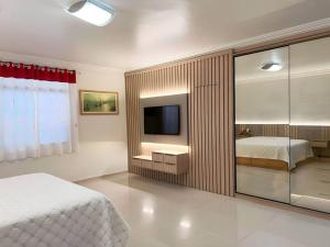 マセイオにあるCasa em Maceió 15min da Praia!のベッドと壁掛けテレビのある寝室 +20枚の写真