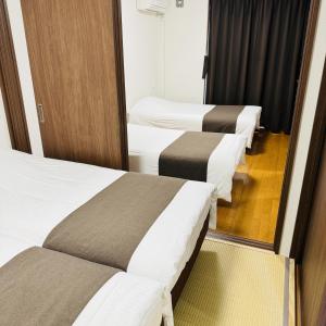 a row of beds in a hotel room at Thanyaporn Hotel in Takayama