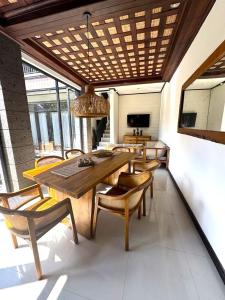 a dining room with a wooden table and chairs at Villa CUCU - Legian - 3 Bedroom in Legian