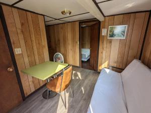 una piccola stanza con un letto, una scrivania e un tavolo di Tiny Wood Cottage 09 a Wasaga Beach