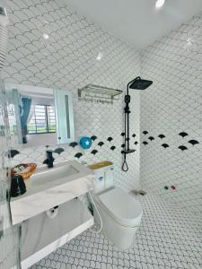 a white bathroom with a toilet and a sink at Sky Star 3 Hotel in Can Tho +9 photos