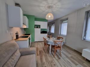 Una sala de estar con una mesa y una cocina. en Charmante Maison 50 m² avec Terrasse et Parking - Tout Inclus, Proche Cambrai et Activités Nautiques - FR-1-510-202, en Iwuy
