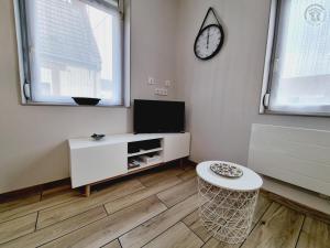 Una sala de estar con un televisor y una mesa. en Charmante Maison 50 m² avec Terrasse et Parking - Tout Inclus, Proche Cambrai et Activités Nautiques - FR-1-510-202, en Iwuy