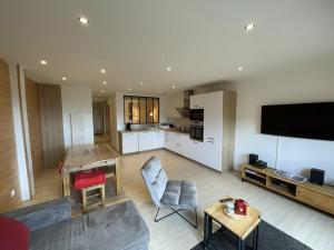a large living room with a kitchen and a television at Appartement cosy 6 couchages, accès pistes, parking - FR-1-787-1 in Saint-Jacques-des-Blats