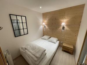 a small bedroom with a bed and a mirror at Appartement cosy 6 couchages, accès pistes, parking - FR-1-787-1 in Saint-Jacques-des-Blats